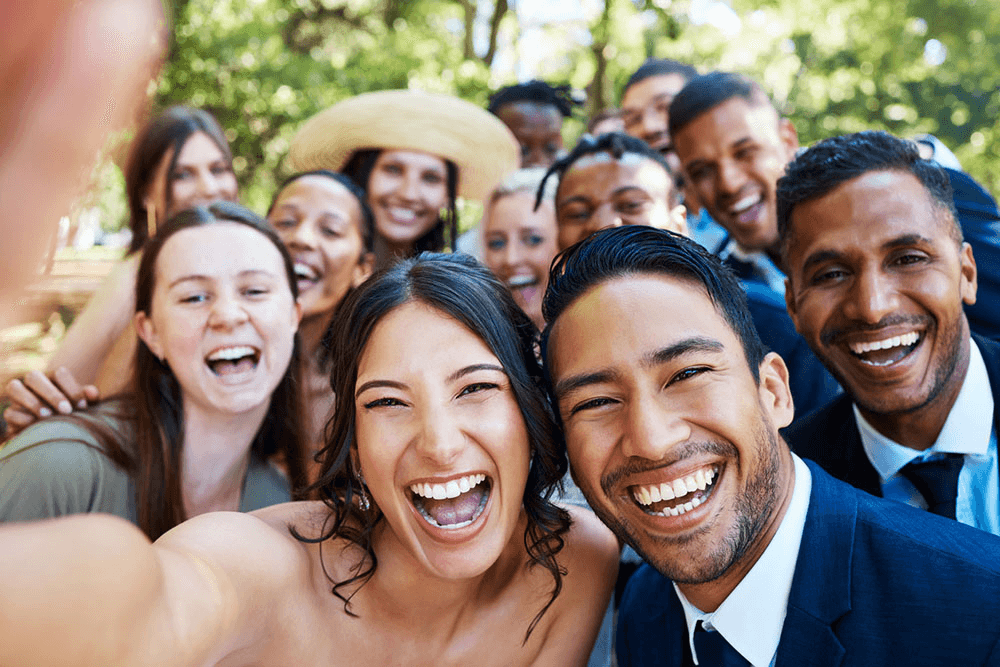 Happy wedding guests taking videos